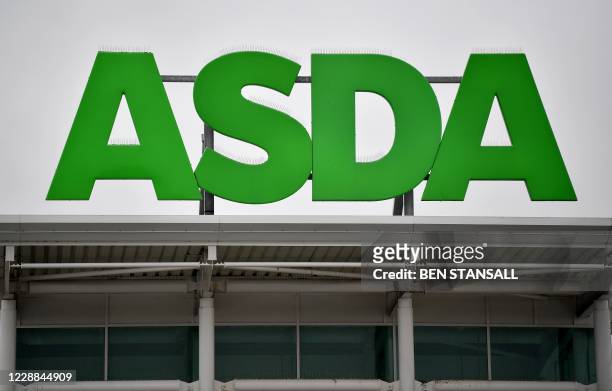 Logos of supermarket chain Asda are pictured on the handles of shopping trolleys outside a store in Ashford, south east England on October 2, 2020. -...