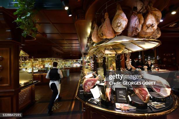 Waiter passes by the ham buffet at the "Les Grands Buffets" restaurant on October 2, 2020 in Narbonne, a day after its re-opening following a six...