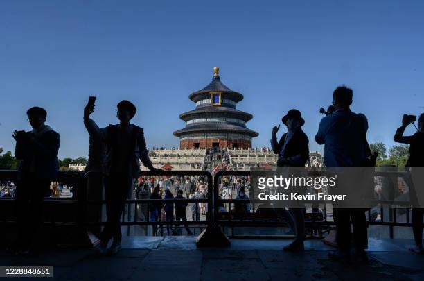 Chinese tourists take photos as they visit the Temple of Heaven on October 2, 2020 during the national holiday in Beijing, China. China is...