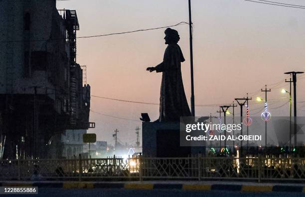 This picture taken on August 17, 2020 shows the statue of the poet Abu Tammam, erected in the centre of a square in the western half of Iraq's...