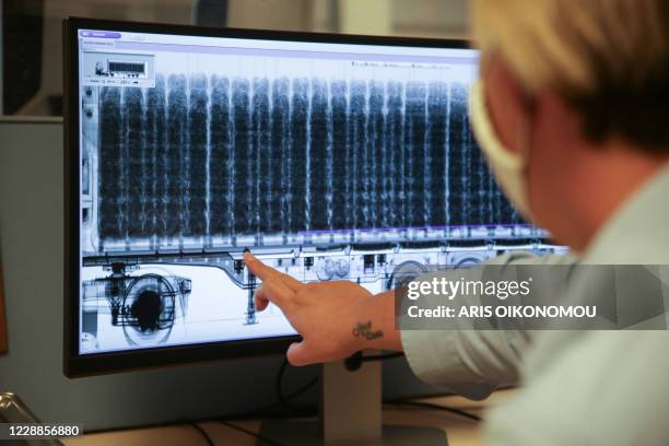 Am employee shows an x-ray scan of a truck carrying a cocaine load at the Antwerp Port on September 28, 2020. - Grenade explosions, shootings and...