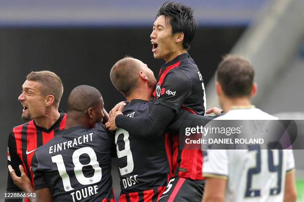 Frankfurt's Japanese midfielder Daichi Kamada celebrates with teammates after scoring the 1-1 goal during the German first division Bundesliga...