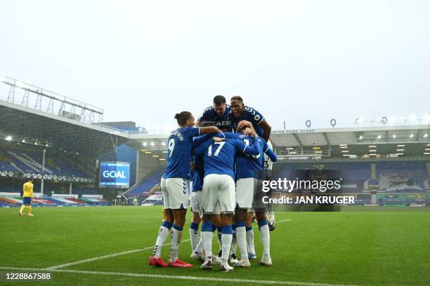 Everton's Colombian midfielder James Rodriguez celebrates with teammates after scoring their third goal during the English Premier League football...