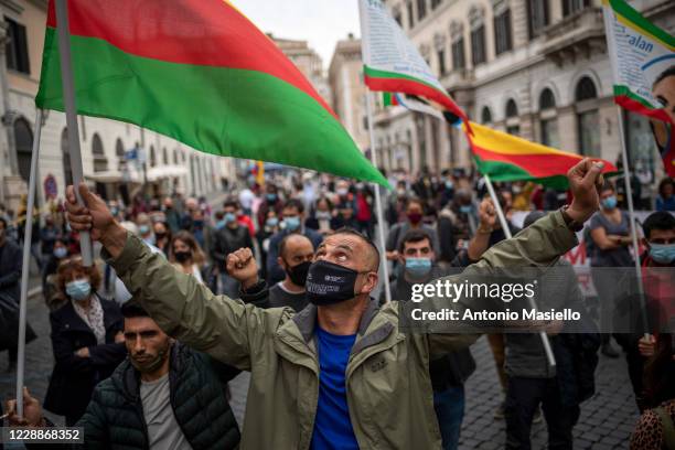 Demonstrators hold flags during a protest against Italian government and immigration policies as part of the National Day in Remembrance of the...