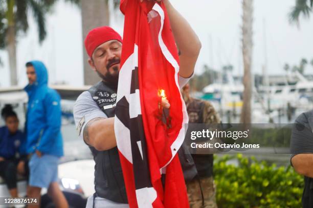 President Donald Trump supporter Gary Snell burns a Nazi flag during a counter-protest against a demonstration billed as a "Rally Against Hate and...