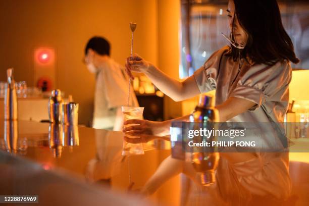 This picture taken on August 1, 2020 shows a bartender making a cocktail in a non-alcoholic bar in Tokyo. At a trendy Tokyo cocktail bar, customers...