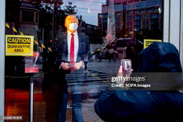 Person taking pictures on the figure. The wax figure of US President Donald Trump has also been 'quarantined' at Madame Tussauds, in Amsterdam. The...