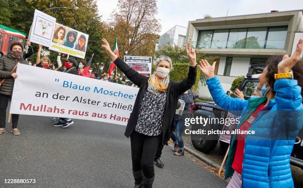 October 2020, Hamburg: Participants of a demonstration dance in front of a banner with the inscription ""Blaue Moschee an der Alster schließen!...