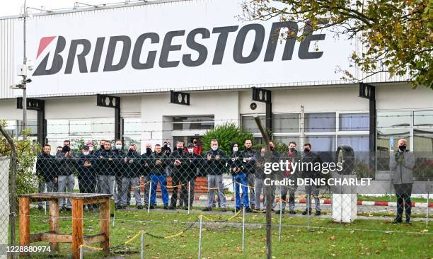 Employees of the Bridgestone plant clap as they watch people taking part in a demonstration to protest against the announced closure of the plant in...