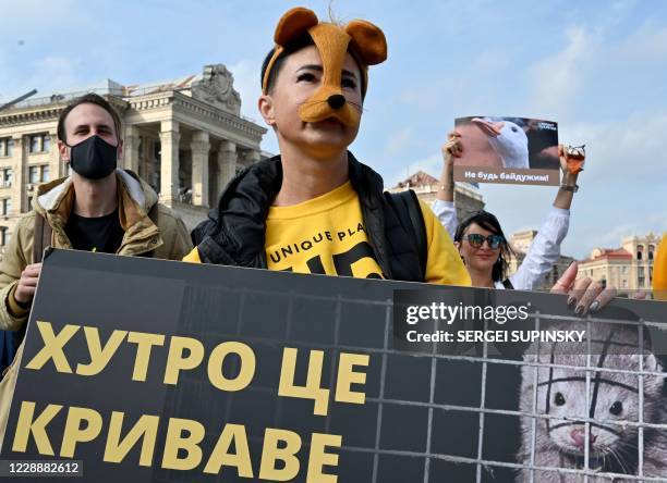 Animal rights activists hold placard as they rally to mark World Animal Day at Independence Square in the Ukrainian capital Kiev, on October 4, 2020....
