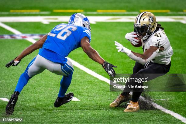 Alvin Kamara of the New Orleans Saints jukes Duron Harmon of the Detroit Lions during the fourth quarter at Ford Field on October 4, 2020 in Detroit,...