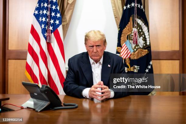 In this handout provided by The White House, President Donald Trump participates in a phone call with Vice President Mike Pence, Secretary of State...