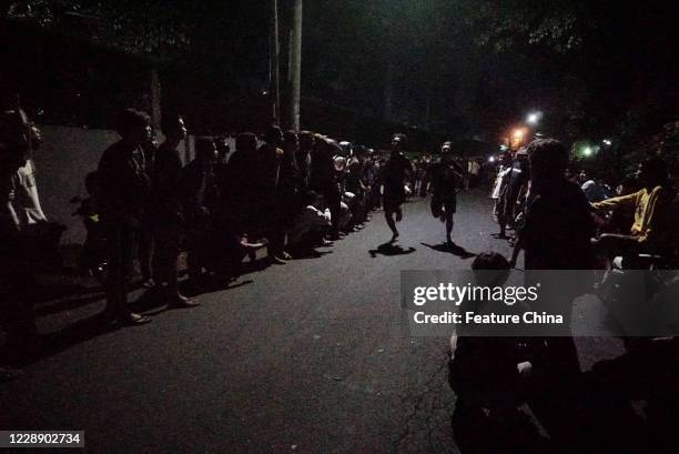 People watch an illegal sprint race in Cibinong area, Bogor Regency, West Java, after midnight Saturday, Sept. 12, 2020. Despite of being an unlawful...