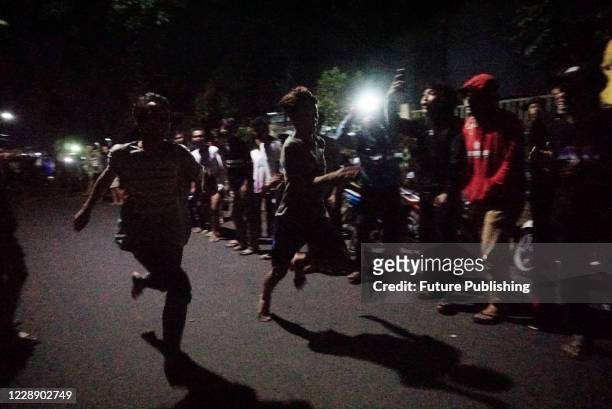 People watch an illegal sprint race in Cibinong area, Bogor Regency, West Java, after midnight Saturday, Sept. 12, 2020. Despite of being an unlawful...