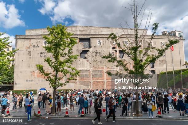 Tourists visit the iconic wall of Sihang warehouse, which witnessed a heroic fight by Chinese soldiers against the Japanese invaders in 1937, in...