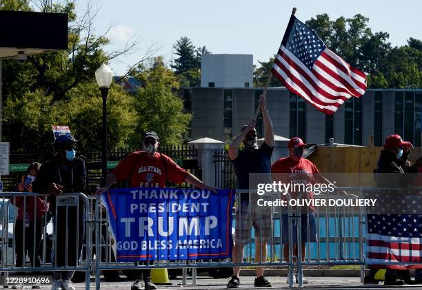 Supporters of US President Donald Trump wave flags outside Walter Reed National Military Medical Center on October 5, 2020 in Bethesda, Maryland. -...
