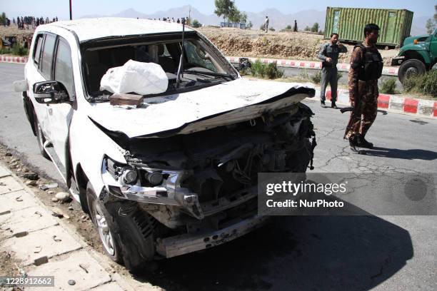 Afghan security force members inspect the site of a car bomb attack that targeted Laghman provincial governor's convoy, in Mihtarlam, Laghman...