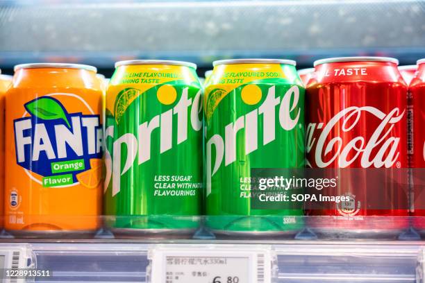 Cans of Coca-Cola, Sprite and Fanta, beverages produced by the Coca-Cola Company, seen displayed in a supermarket.