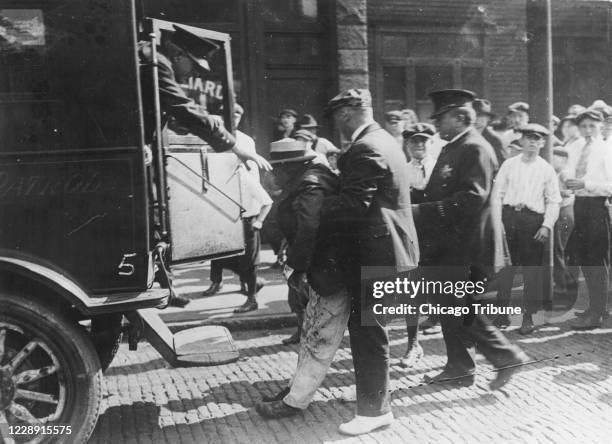 Race riots in Chicago. A dead black man is placed in a Chicago Police patrol wagon, a victim of the ongoing race riots.