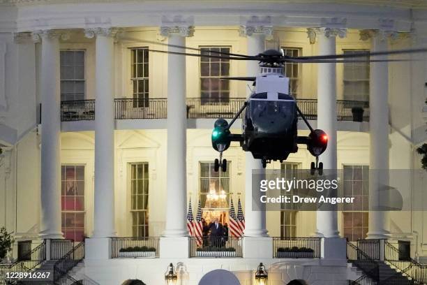 President Donald Trump stands on the Blue Room Balcony as Marine One, takes off from the South Lawn of the White House on October 5, 2020 in...