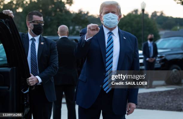 President Donald Trump pumps his fist as he leaves Walter Reed Medical Center in Bethesda, Maryland heading towards Marine One on October 5 to return...