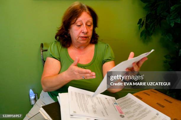 Maria Aurora Estevez, 64 years old, shows legal documents during an interview with AFP in Miami, Florida on September 29, 2020. - Davion and Maria,...