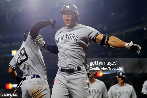 Giancarlo Stanton of the New York Yankees is greeted by teammate Gio Urshela after hitting a grand slam in the ninth inning during Game 1 of the ALDS...