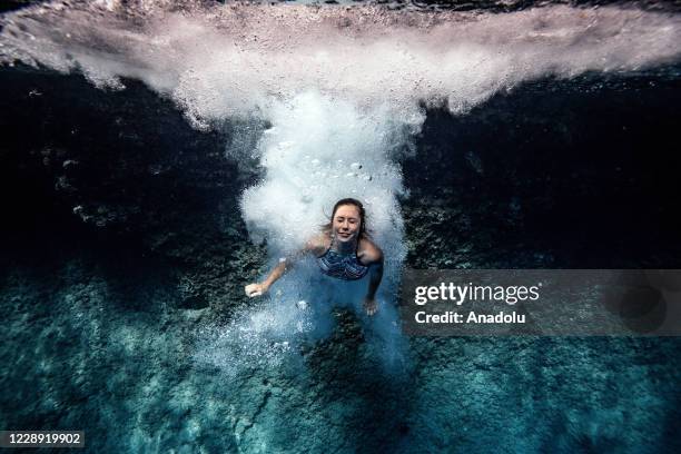Woman dives into the clear water of "Suluada" located 7 kilometers from another favorite spot location for deep water soloing Cape Gelidonya, in...