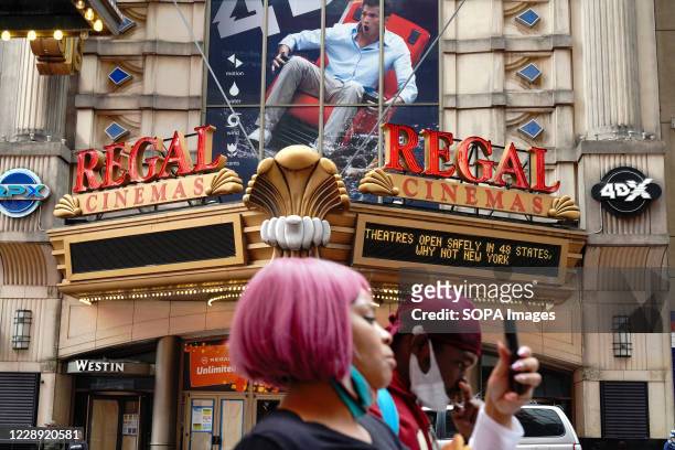Woman walks past the Regal Cinemas. Regal Cinemas which is the second-largest operator of theatres in the United States, plans to close all 500 US...