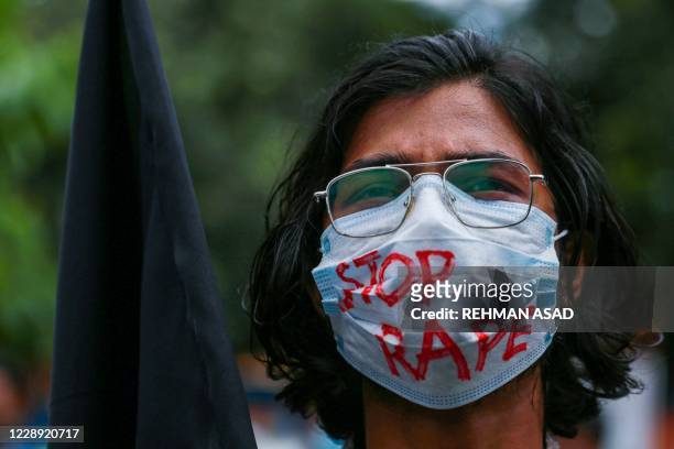 Student holds a black flag to protest against an alleged gang-rape and stripping and torturing of a woman in the southern district of Noakhali during...