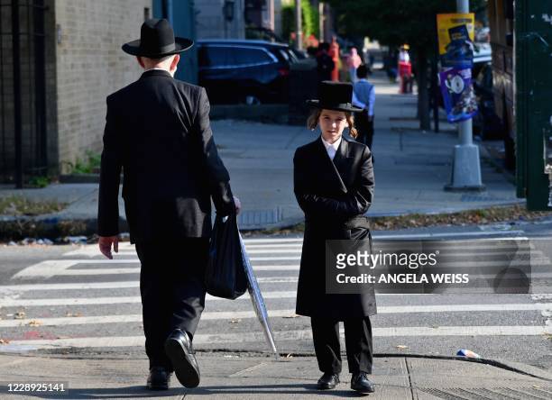 Hasidic males without facemasks walk in the Brooklyn neighborhood of Borough Park on October 6, 2020 in New York City.