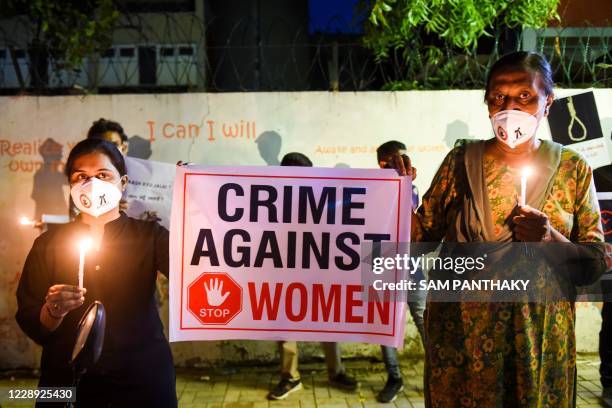 Lawyers display a placard to condemn the alleged gang-rape and murder of a low-caste teenaged woman in Uttar Pradesh state during a candlelight vigil...