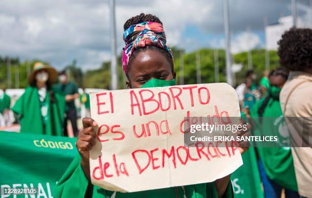 Woman holds a placard reading "Abortion is a Debt of Democracy" during a demonstration in support of the decriminalization of abortion in three...