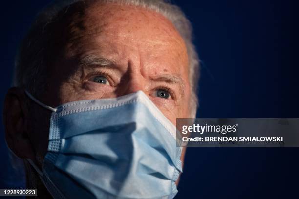 Democratic presidential candidate former US Vice President Joe Biden wears a facemask as he speaks to the media before boarding his plane at...