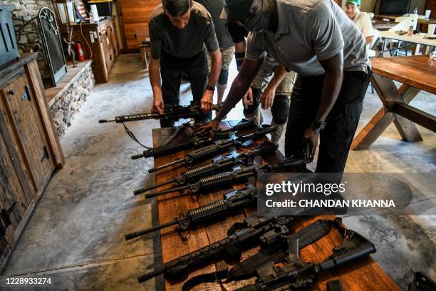 Students place their AR-15 semi-automatic rifles on a bench during a shooting course at Boondocks Firearms Academy in Jackson, Mississippi on...