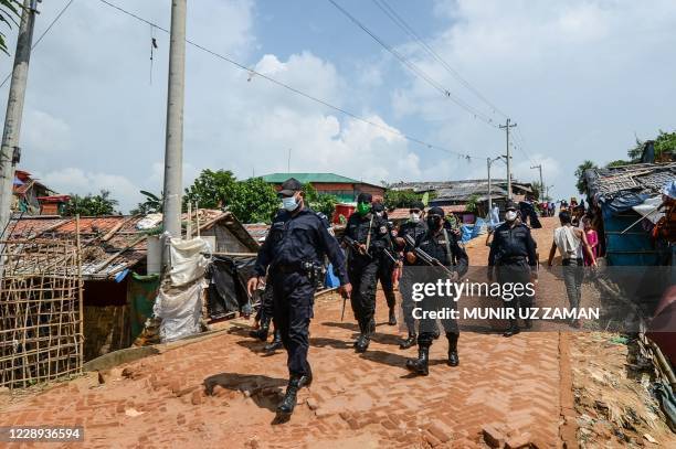 Bangladesh Rapid Action Battalion personnel patrol on the street at Jamtoli refugee camp near Cox's Bazar on October 7, 2020. - Bangladesh has sent...