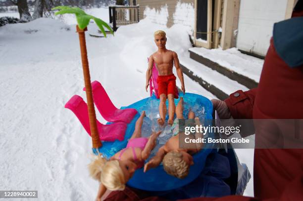 Man carries out Barbie and Ken on ice in a hot tub during the Winter Swim Festival at Lake Memphremagog in Newport, VT on Feb. 29, 2020. In waters...