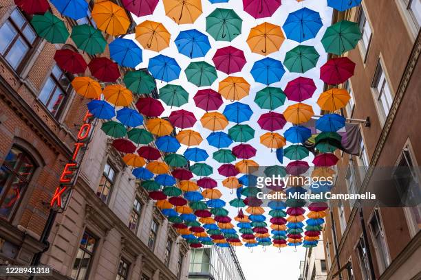 An installation entitled "Umbrella Sky Project" created by Portuguese artist Patricia Cunha and composed of suspended colorful umbrellas is seen on...