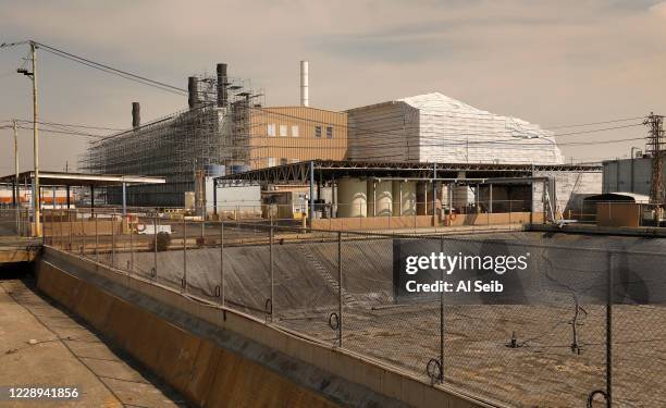 Portions of the Exide Technologies, lead-acid battery recycling plant located in Vernon are wrapped in white plastic even as a press conference with...