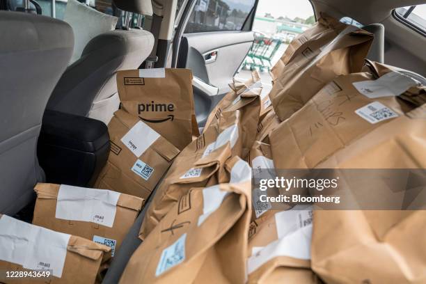 Amazon Prime grocery bags sit inside a car outside a Whole Foods Market in Berkeley, California, U.S., on Wednesday, Oct. 7, 2020. With millions of...