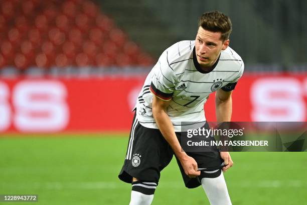 Germany's midfielder Julian Draxler adjusts his socks during the international friendly football match between Germany and Turkey in Cologne, western...