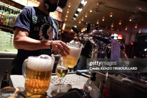 Waiter serves beers at a bar on the eve of the mandatory closure of bars in Brussels, on October 7 to stop the spread of Covid-19. - In Brussels,...
