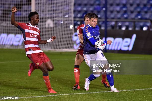 Oldham Athletic's Zak Dearnley and Doncaster Rovers' Madger Gomes and Tom Anderson during the EFL Trophy match between Oldham Athletic and Doncaster...