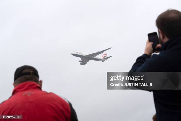 Plane spotters watch as a British Airways Boeing 747 aircraft makes a flypast over London Heathrow airport on it's final flight, in London on October...