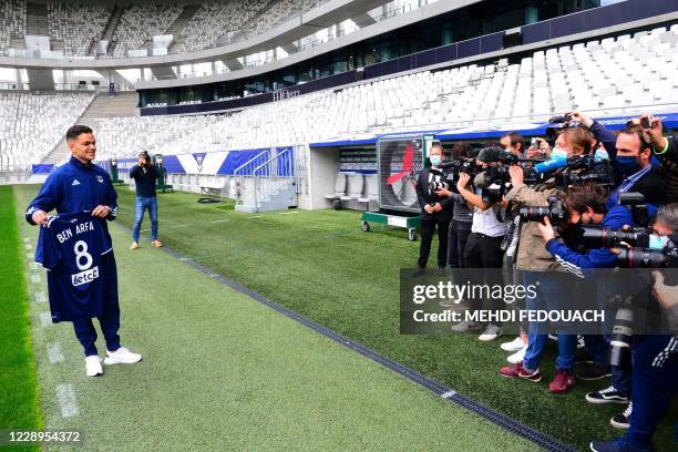 New Bordeaux' French forward Hatem Ben Arfa poses for photographers with his new jersey on the pitch following his first training session and his...