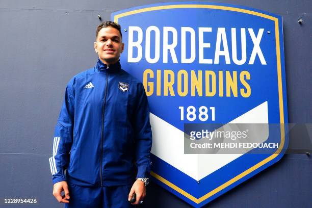 New Bordeaux' French forward Hatem Ben Arfa poses past the logo of his new team during a press conference held for his presentation at the Matmut...