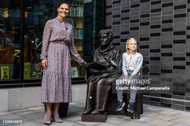 Crown Princess Victoria of Sweden participates in a ribbon cutting ceremony with child Maija Sinisalo during an inauguration ceremony for a sculpture...