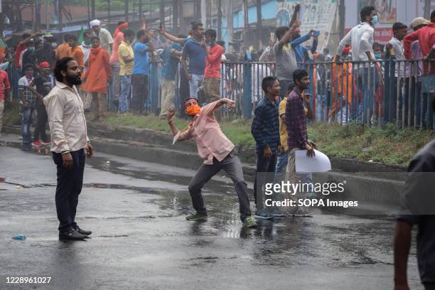 Worker throws stones towards the police officers during the demonstration. Thousands of BJP members and workers organised a protest against the...