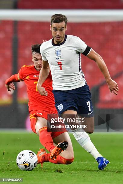 England's midfielder Harry Winks is tackled by Wales' midfielder Dylan Levitt during the international friendly football match between England and...