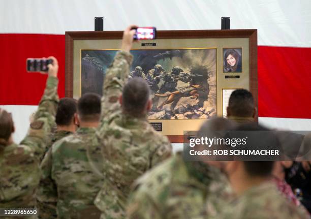 Members of the Air National Guard view the painting honoring Kayla Mueller, a humanitarian and Prescott native during a ceremony at the Goldwater Air...